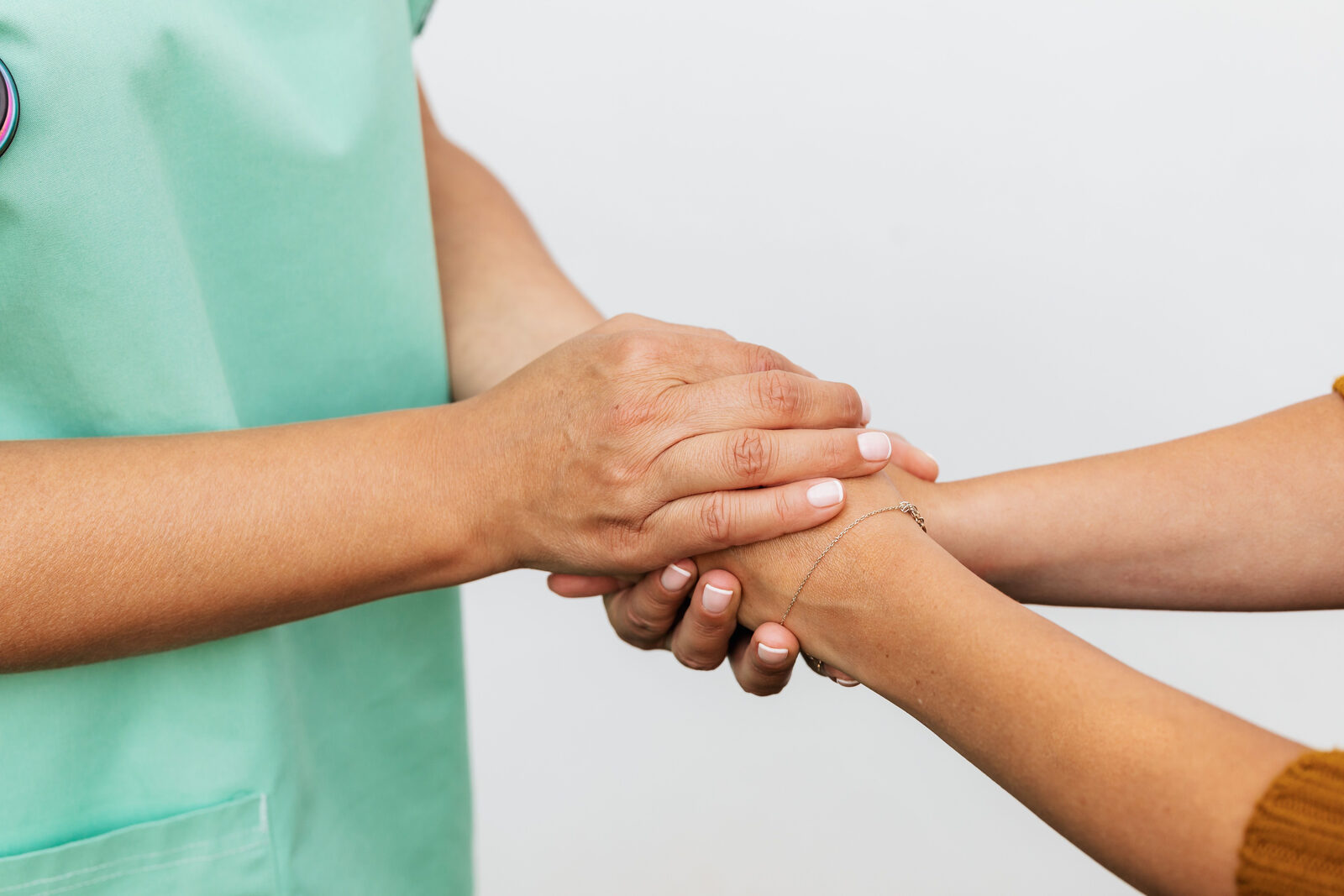 Patients and caregivers holding hands in support
